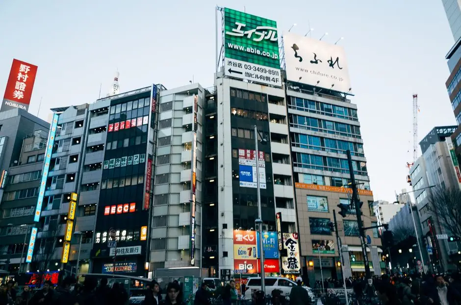 Dynamic view of a bustling Tokyo street with colorful billboards and busy pedestrian traffic.