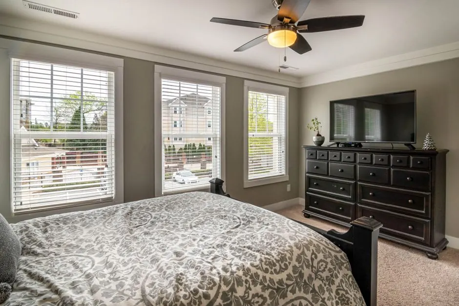 Spacious bedroom featuring elegant decor, modern furniture, and abundant natural light.